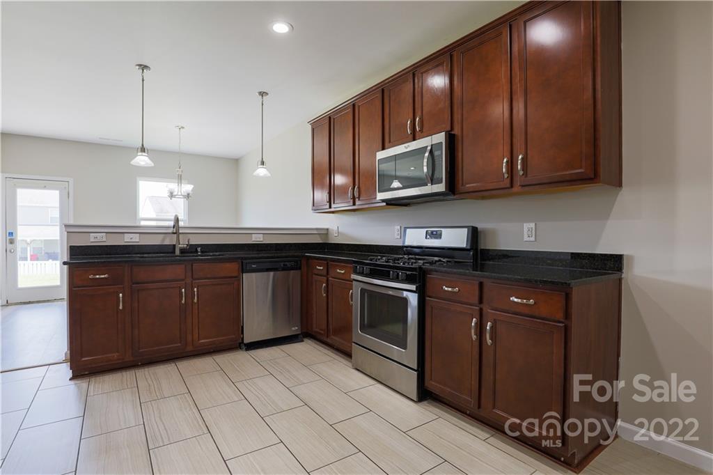 12507 Bending Branch Road Charlotte, NC 28227 - Photo 9 of 23 a large kitchen with stainless steel appliances granite countertop a sink a stove a microwave and cabinets