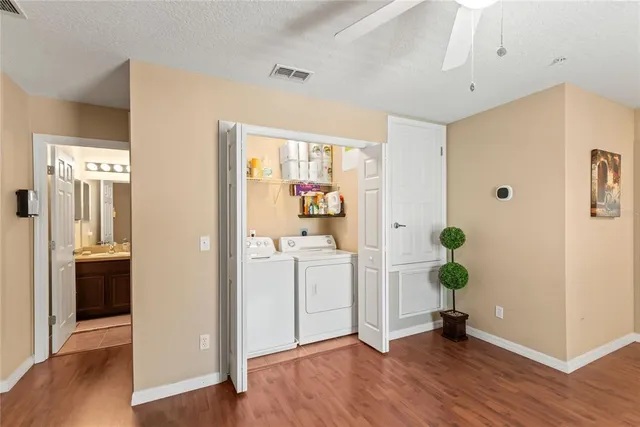 a view of a hallway with wooden floor and a bathroom