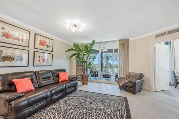 a living room with furniture and a large window with garden view