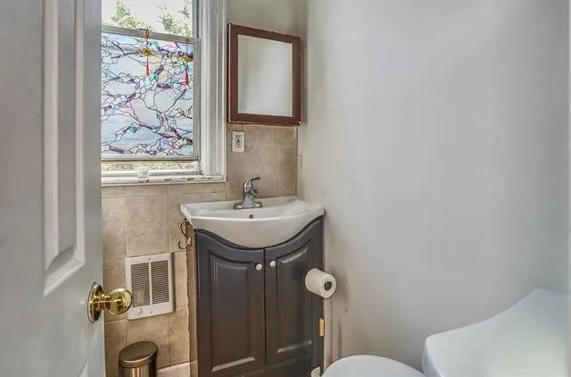 a bathroom with a sink mirror and toilet