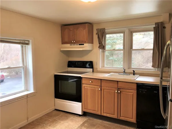 a kitchen with stainless steel appliances a stove sink and window