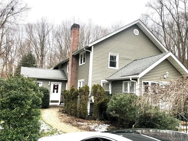 a view of a house next to a yard with plants and trees