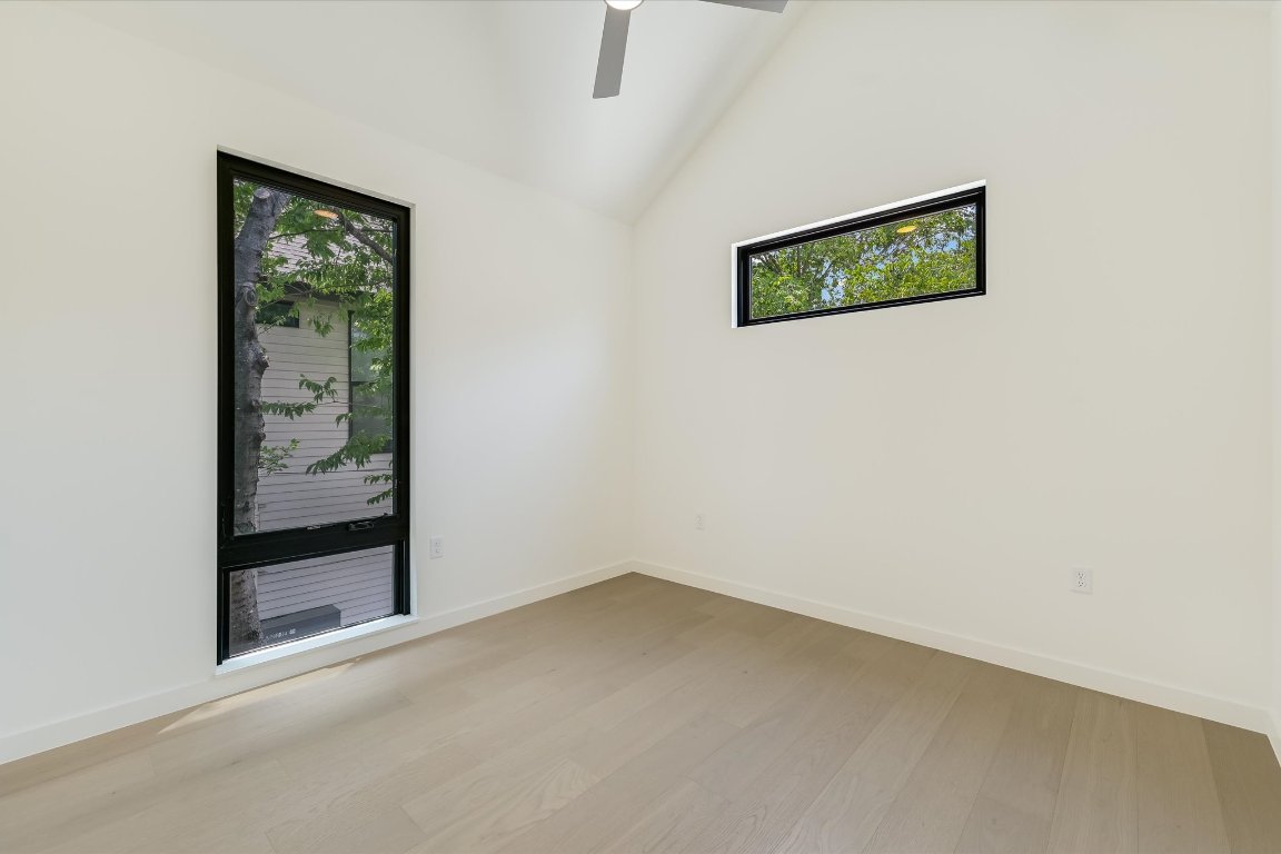 2705 Francisco Street, Unit A Austin, TX 78702 - Photo 17 of 21 Unfurnished room featuring lofted ceiling, wood finished floors, and ceiling fan