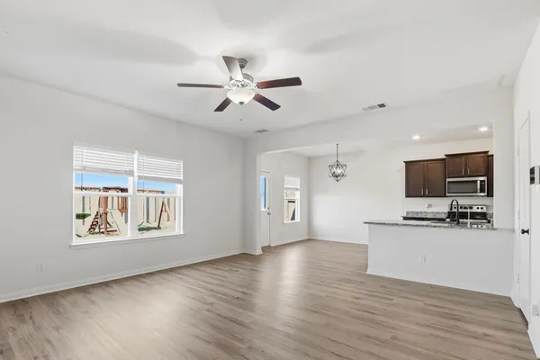 a kitchen with stainless steel appliances a stove a sink a microwave a refrigerator and cabinets