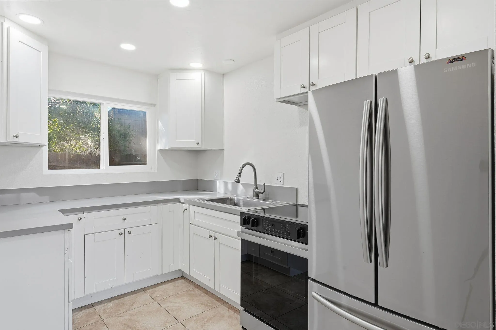 12621 Lindo Lane Lakeside, CA 92040 - Photo 19 of 28 a kitchen with white cabinets and refrigerator