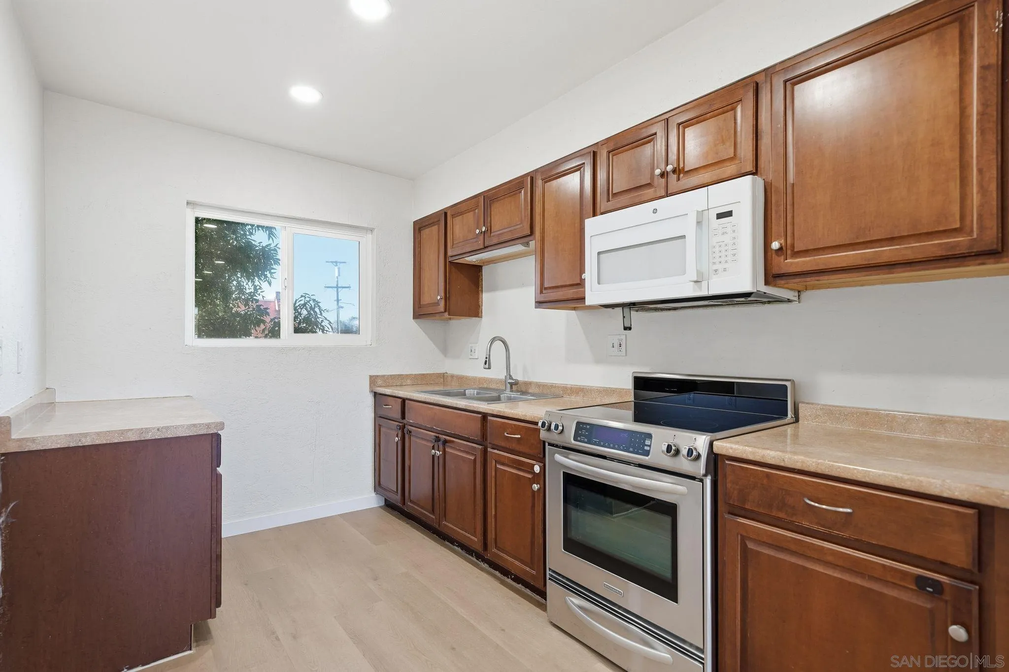 12621 Lindo Lane Lakeside, CA 92040 - Photo 27 of 28 a kitchen with stainless steel appliances granite countertop a stove a sink and a microwave