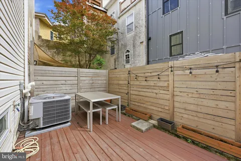 a view of a deck with table and chairs with wooden floor and fence