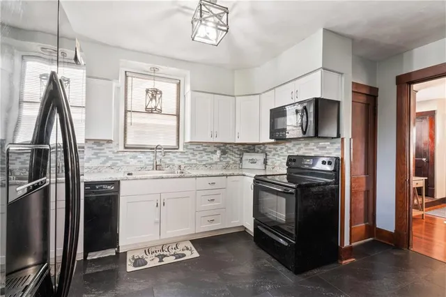 a kitchen with kitchen island granite countertop a stove top oven a sink and a refrigerator