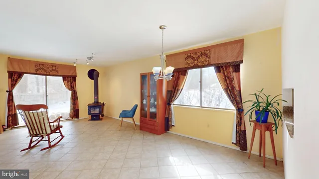 a dining room with furniture and a floor to ceiling window