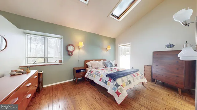 a bedroom with a bed and a dresser next to a window