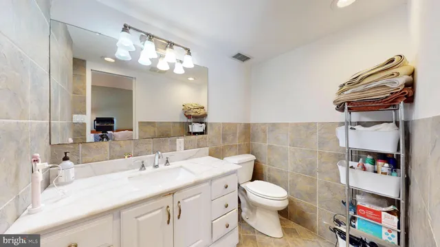 a bathroom with a granite countertop sink a toilet and a mirror
