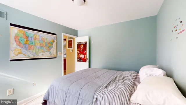 a bedroom with a bed and painting on the wall