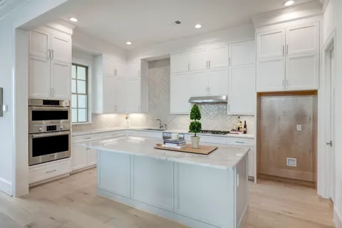 a kitchen with kitchen island white cabinets and refrigerator