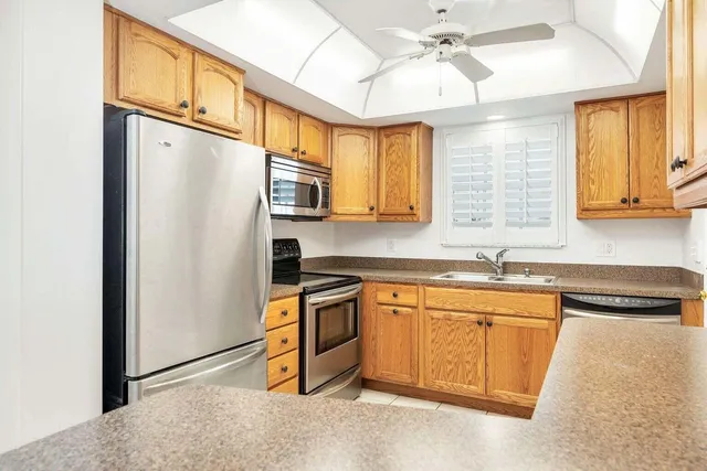 a kitchen with stainless steel appliances granite countertop a refrigerator a sink and dishwasher