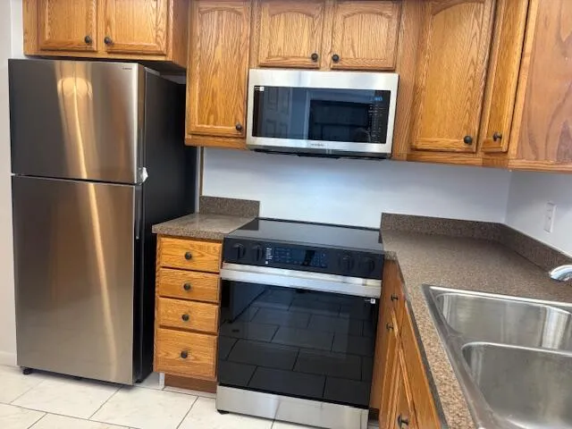 a kitchen with stainless steel appliances granite countertop a refrigerator sink and cabinets