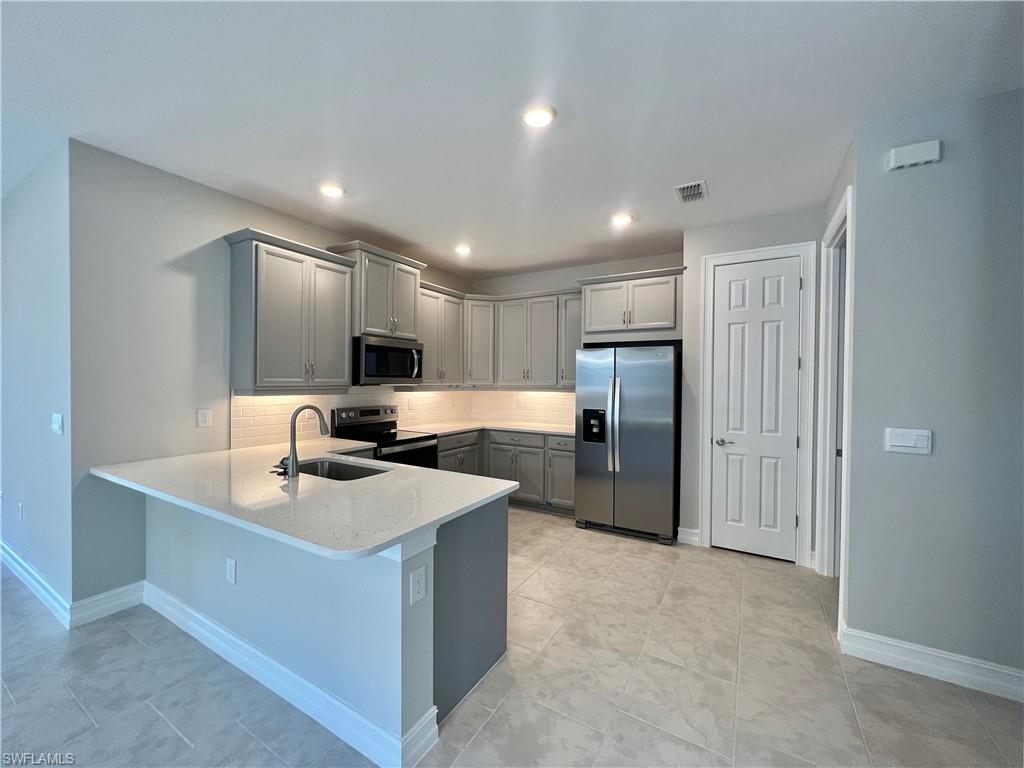 842 Enbrook Loop Naples, FL 34114 - Photo 6 of 23 a large kitchen with a large counter top stainless steel appliances and cabinets