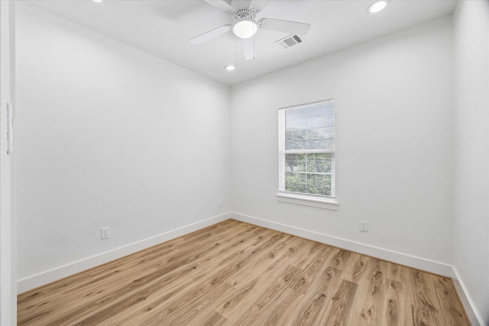 2749 Redrock Street, Unit B Houston, TX 77088 - Photo 20 of 24 The third bedroom has recessed lighting, a ceiling fan with light, window with blinds, luxury vinyl plank hardwood flooring, & a wardrobe closet to the left.