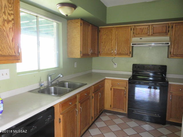 403 Curry Street Rio Rico, AZ 85648 - Photo 4 of 23 a kitchen with stainless steel appliances a sink stove and cabinets