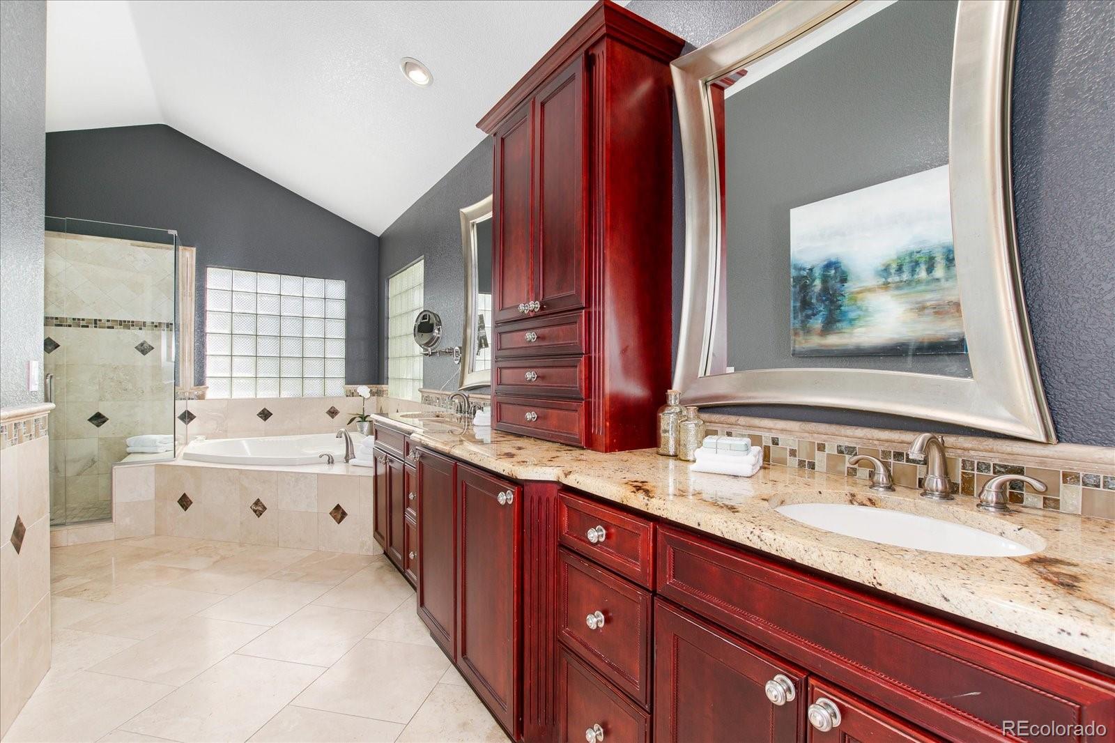 9318 Reed Way Broomfield, CO 80021 - Photo 21 of 33 a spacious bathroom with a granite countertop double vanity sink a mirror and a bathtub