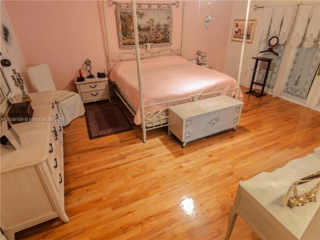 6950 Granada Boulevard Coral Gables, FL 33146 - Photo 14 of 15 a bedroom with a bed and wooden floor