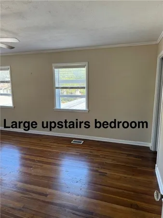 a view of a room with wooden floor and white walls