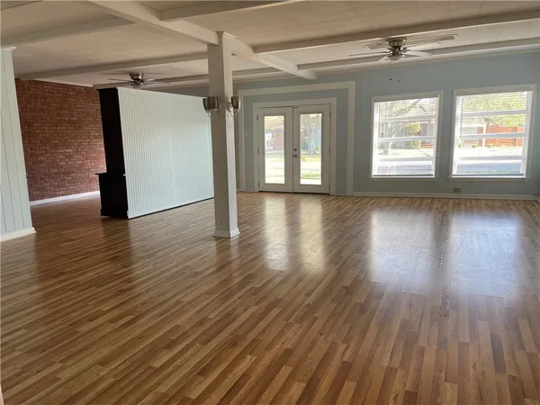 a view of a room with wooden floor and windows
