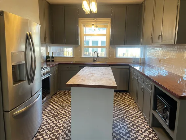 a kitchen with granite countertop stainless steel appliances a sink stove and refrigerator