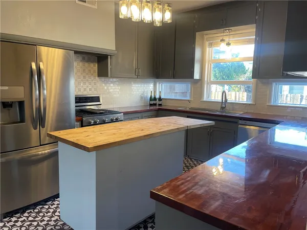 a kitchen with stainless steel appliances granite countertop a sink stove and refrigerator