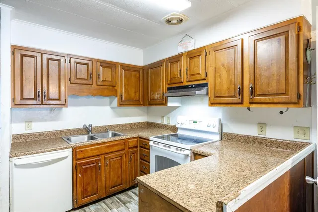 a kitchen with stainless steel appliances granite countertop a sink stove and cabinets