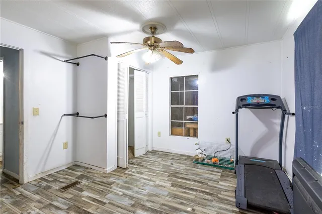 a view of a room with wooden floor and a ceiling fan