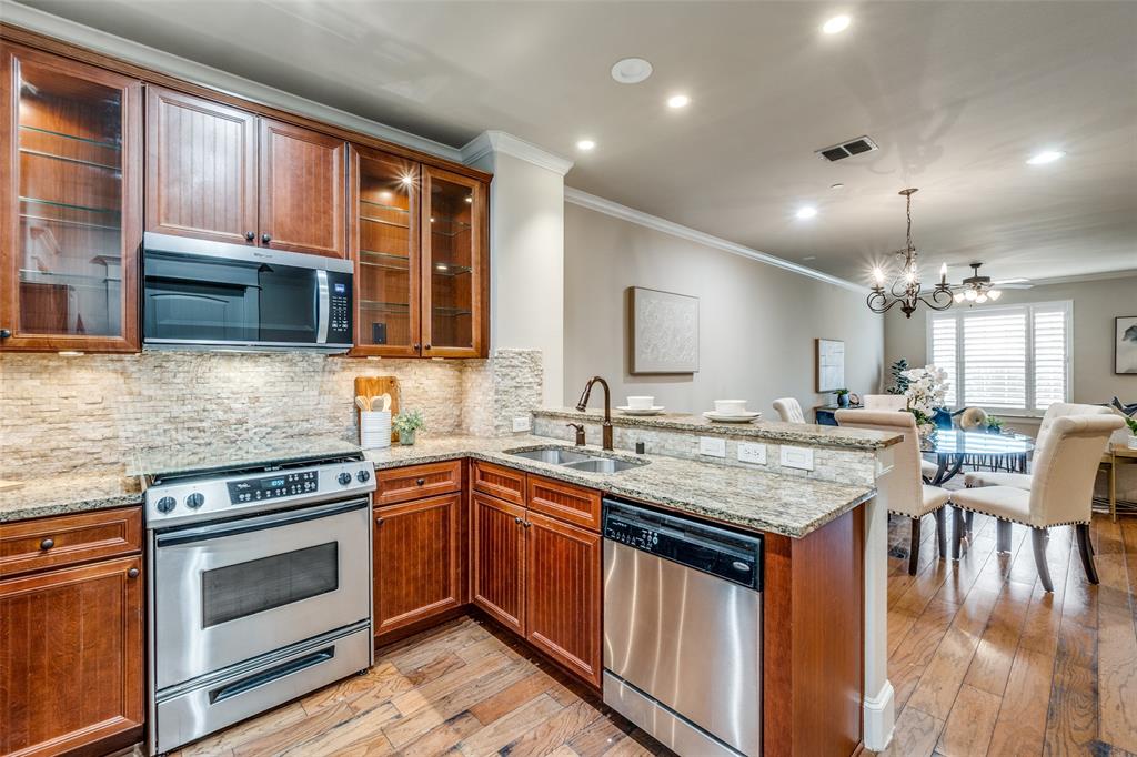 1600 Abrams Road, Unit 54 Dallas, TX 75214 - Photo 13 of 23 a kitchen with stainless steel appliances granite countertop a stove top oven a sink dishwasher a dining table and chairs with wooden floor