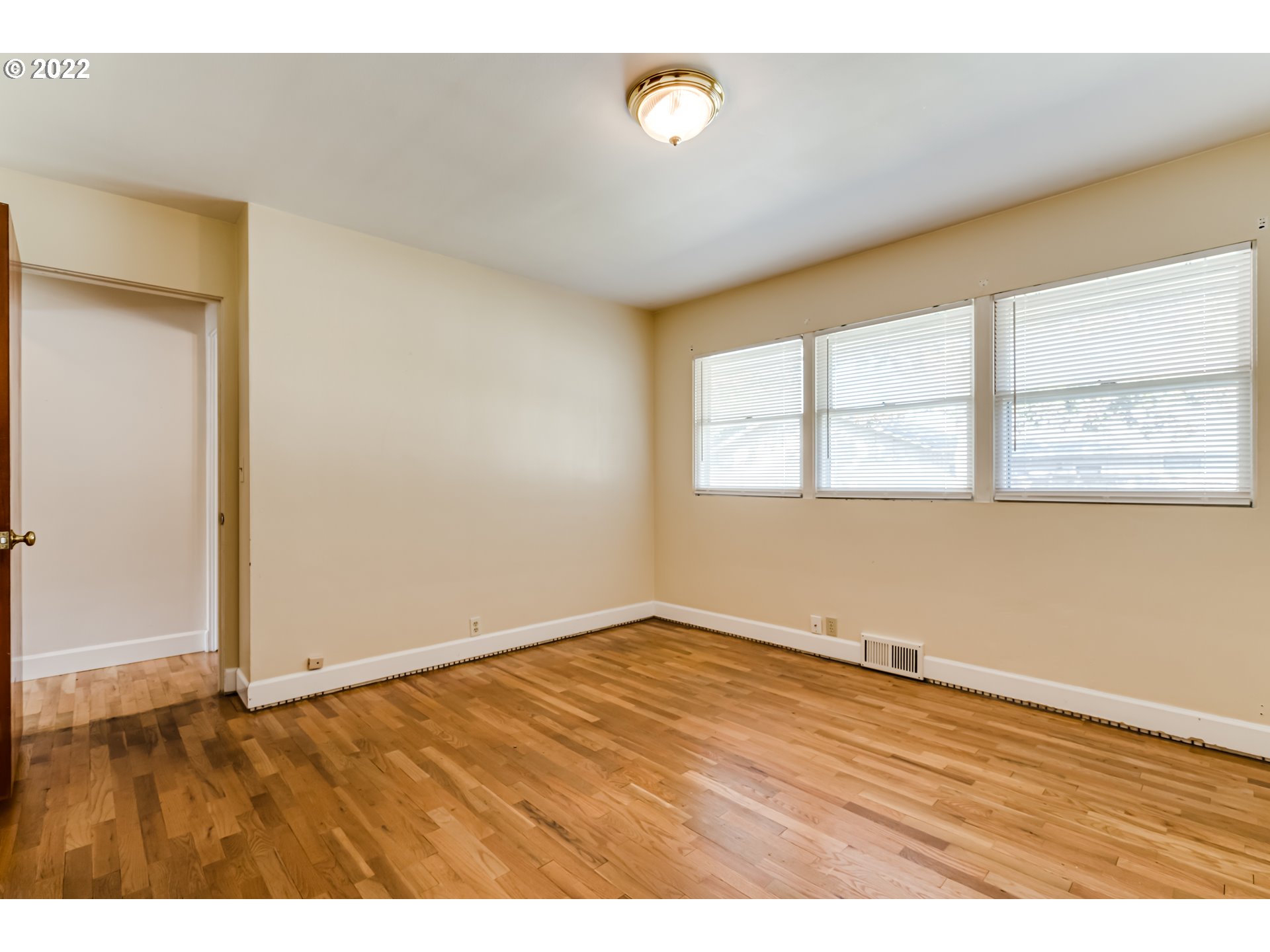 595 Dartmoor Drive Eugene, OR 97401 - Photo 19 of 32 an empty room with wooden floor and windows