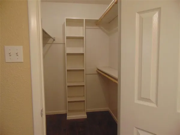 a view of walk in closet with empty racks