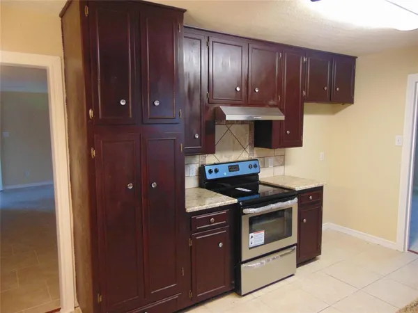 a stove top oven sitting inside of a kitchen