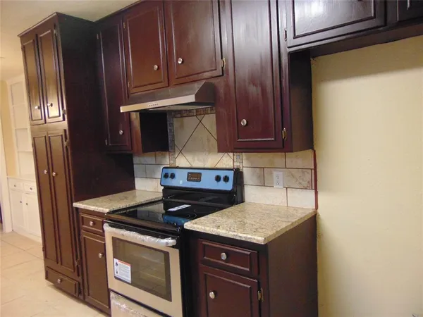 a stove top oven sitting inside of a kitchen