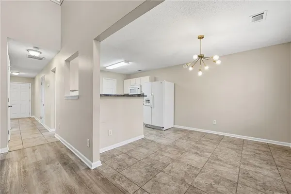 a view of an empty room and kitchen view