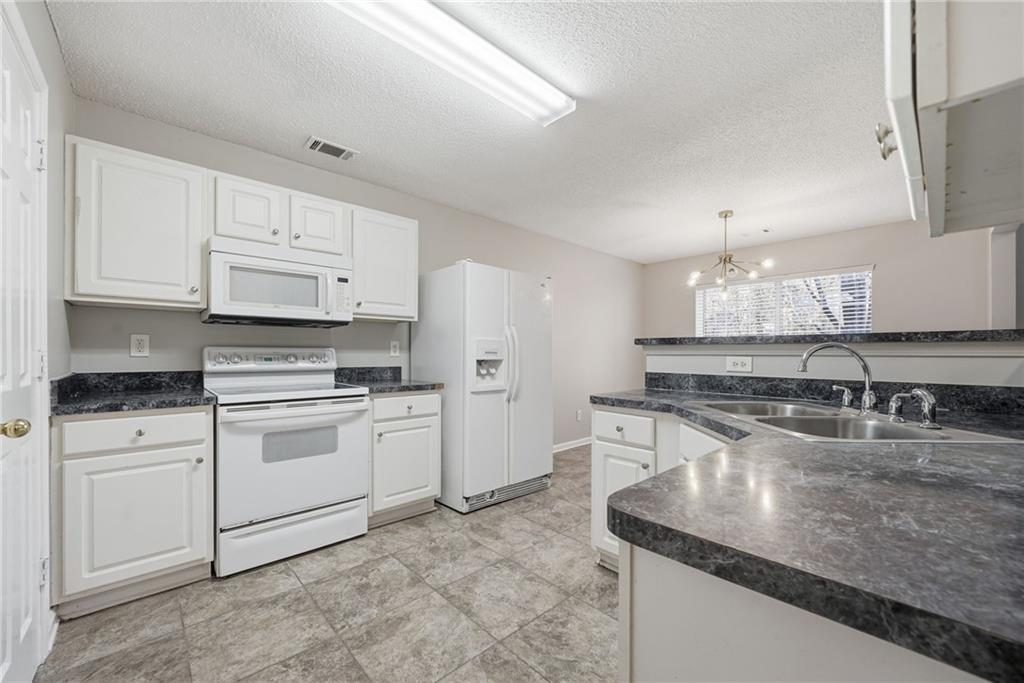 2297 Charleston Pointe Southeast Atlanta, GA 30316 - Photo 2 of 48 a kitchen with stainless steel appliances granite countertop a sink stove and cabinets