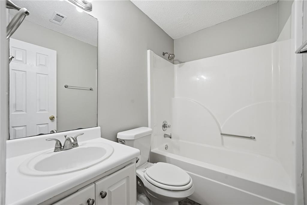 2297 Charleston Pointe Southeast Atlanta, GA 30316 - Photo 22 of 48 a bathroom with a toilet a sink a mirror a bathtub and vanity