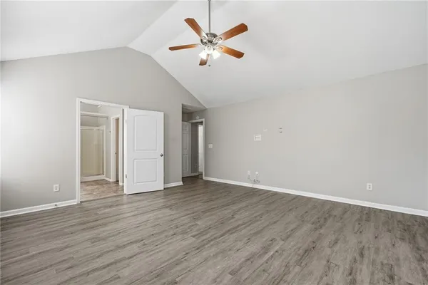 an empty room with wooden floor and ceiling fan