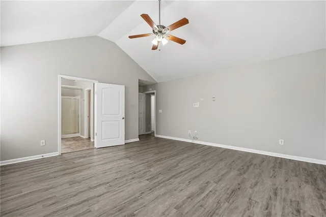 an empty room with wooden floor and ceiling fan