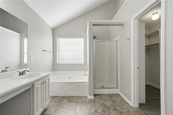 a bathroom with a tub a sink and a mirror