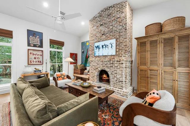 a living room with furniture fireplace and a large window
