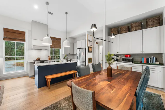 a kitchen with sink refrigerator dining table and chairs