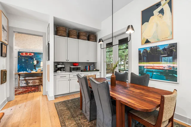 a kitchen with a table chairs and flat screen tv