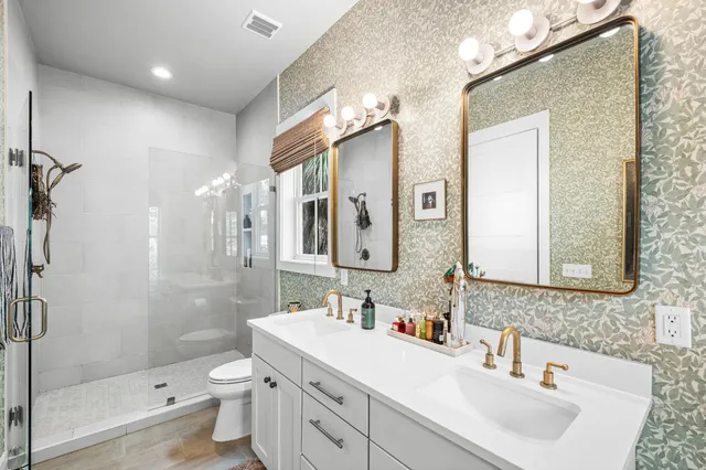 a bathroom with a sink a toilet and shower