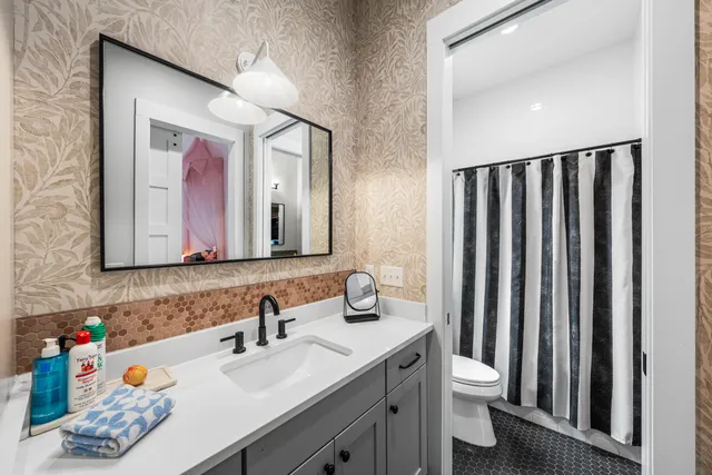 a bathroom with a sink vanity mirror and toilet