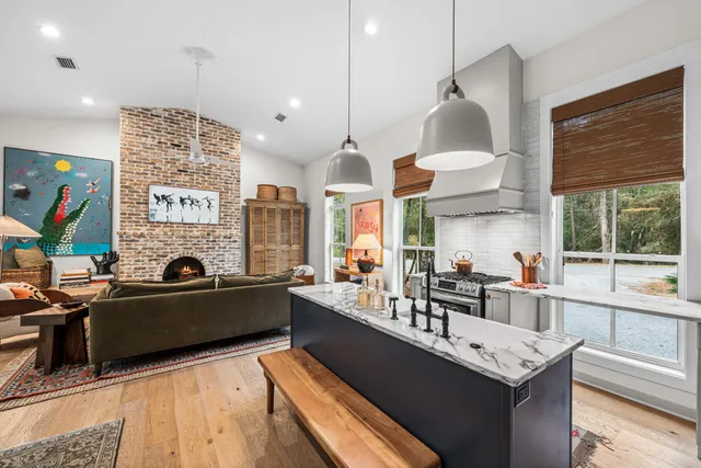 a large kitchen with stainless steel appliances kitchen island granite countertop a sink and a stove