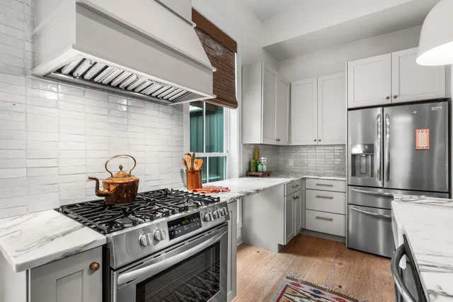 a kitchen with stainless steel appliances granite countertop a stove a refrigerator and a stove