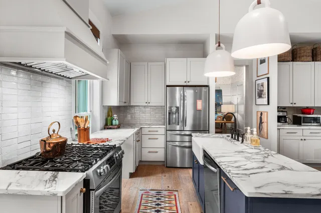 a kitchen with granite countertop a sink stove and refrigerator
