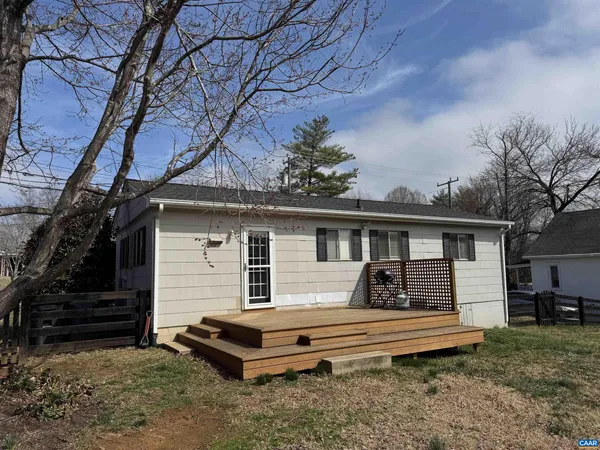 a house view with a sitting space fire pit and outdoor space